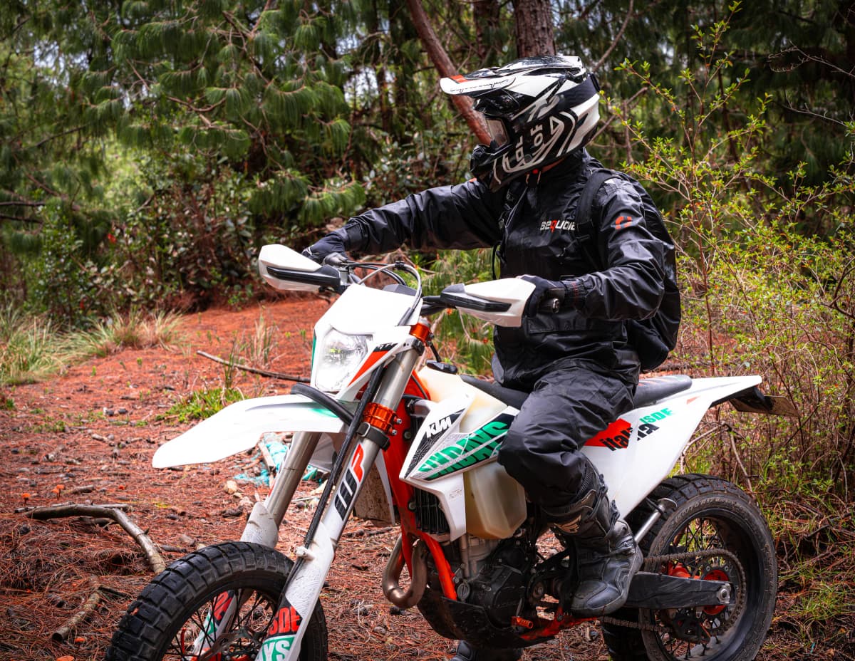 Motociclista en movimiento sobre un sendero de bosque