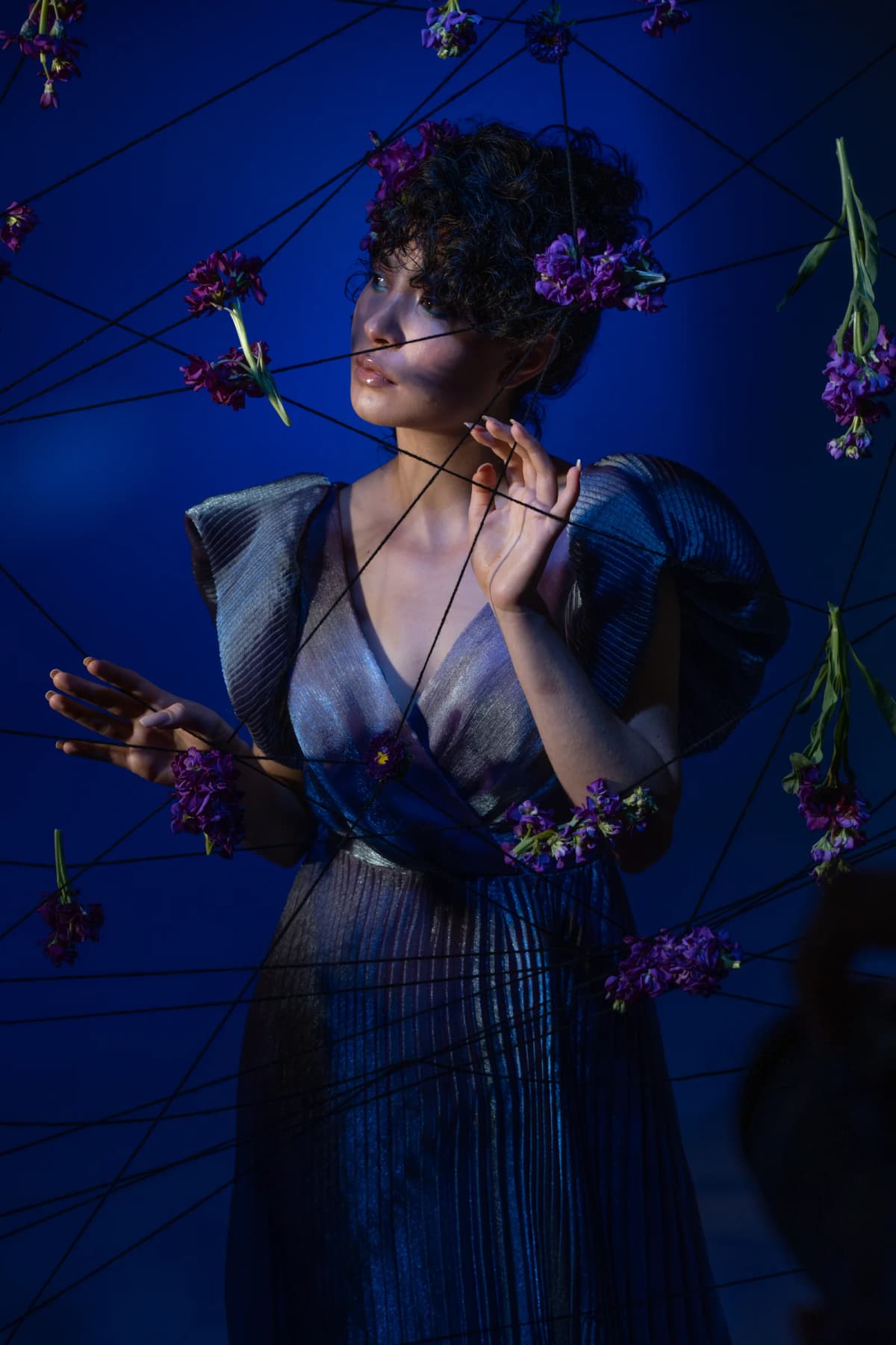 Editorial de moda azul con flores y luz dramática